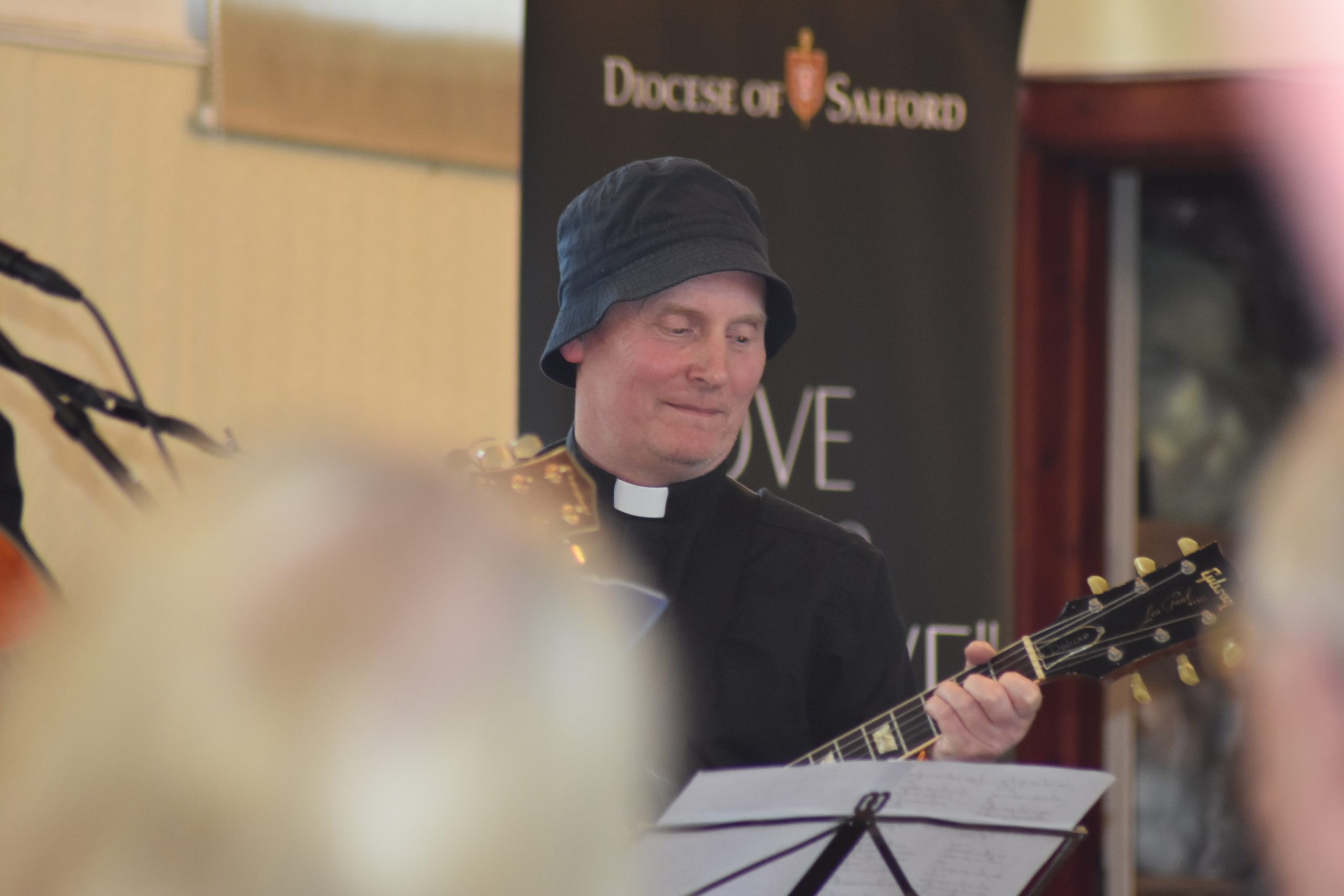 Fr Joe Gee playing the guitar at the Mercy Brothers fundraiser
