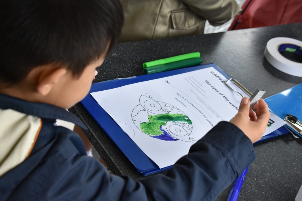 Young boy takes part in educational activity at the Laudato Si' Centre to learn more about how the ecological crisis affects our brothers and sisters around the world