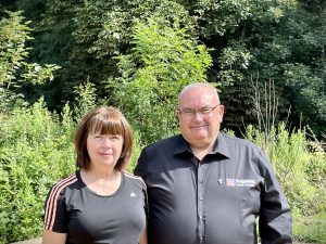 Kathleen and Deacon John stand side-by-side in the woodland at the Laudato Si' Centre, where they both volunteer