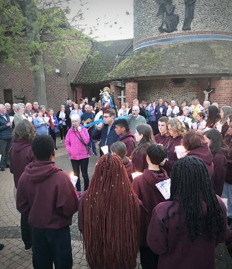 Pilgrims gather outside Catholic Church in Walsingham and hold candles in evening torchlight procession