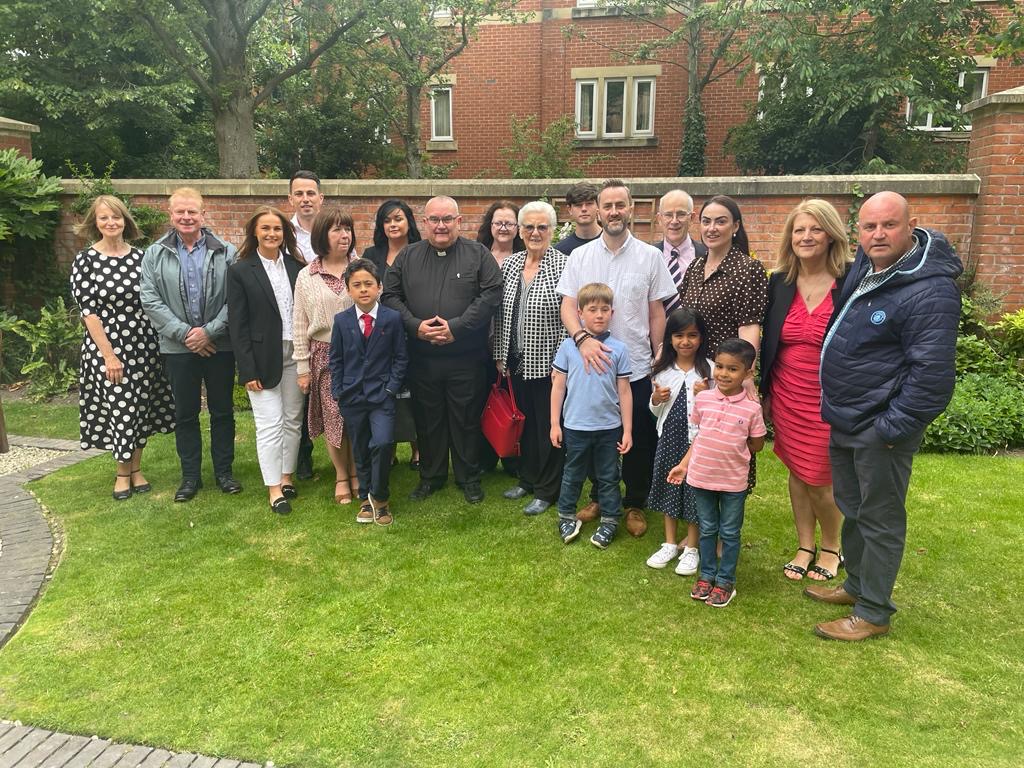 Deacon John is surrounded by his family in the grounds of the cathedral on his ordination day