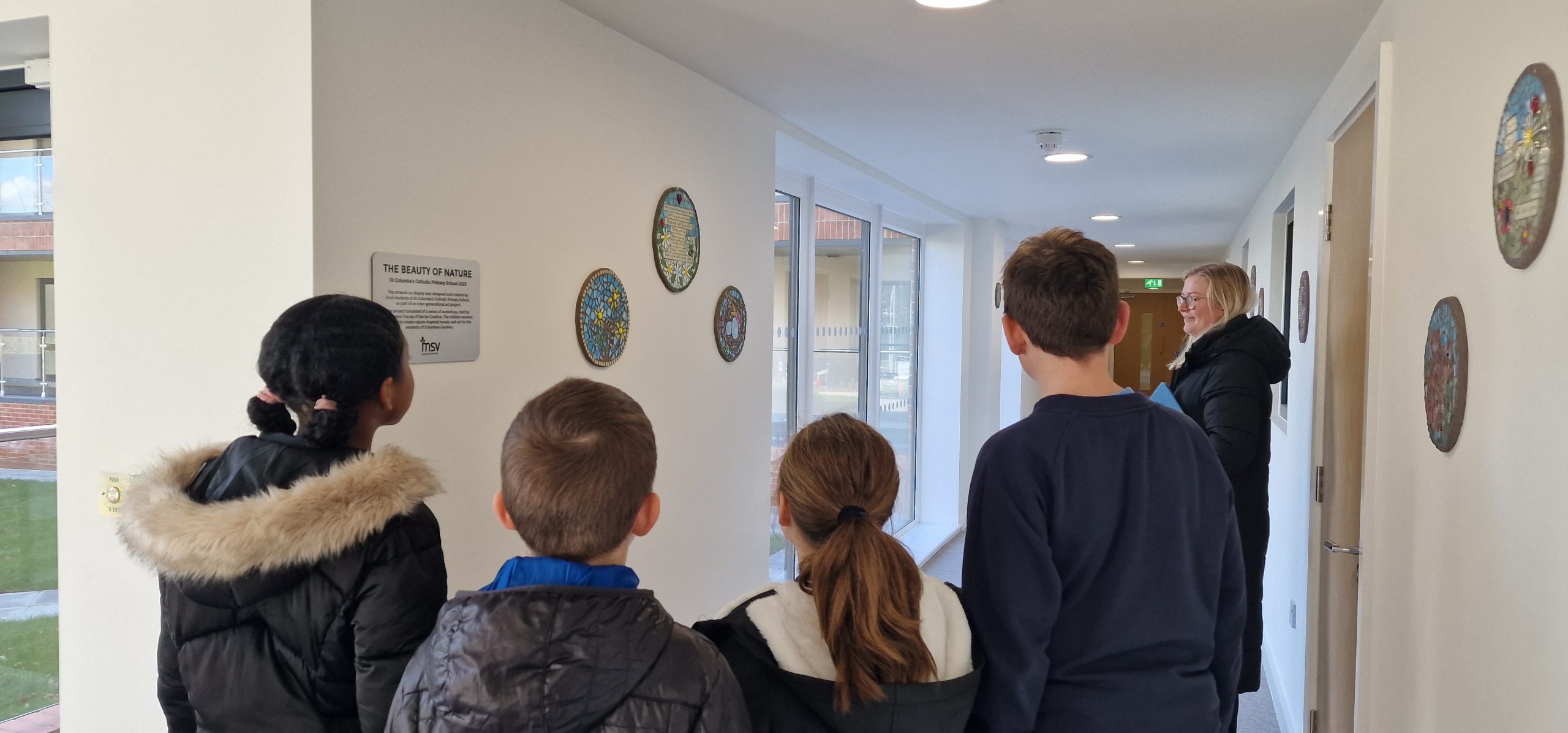 Pupils from St Columba's look at the artwork they produced for the development.